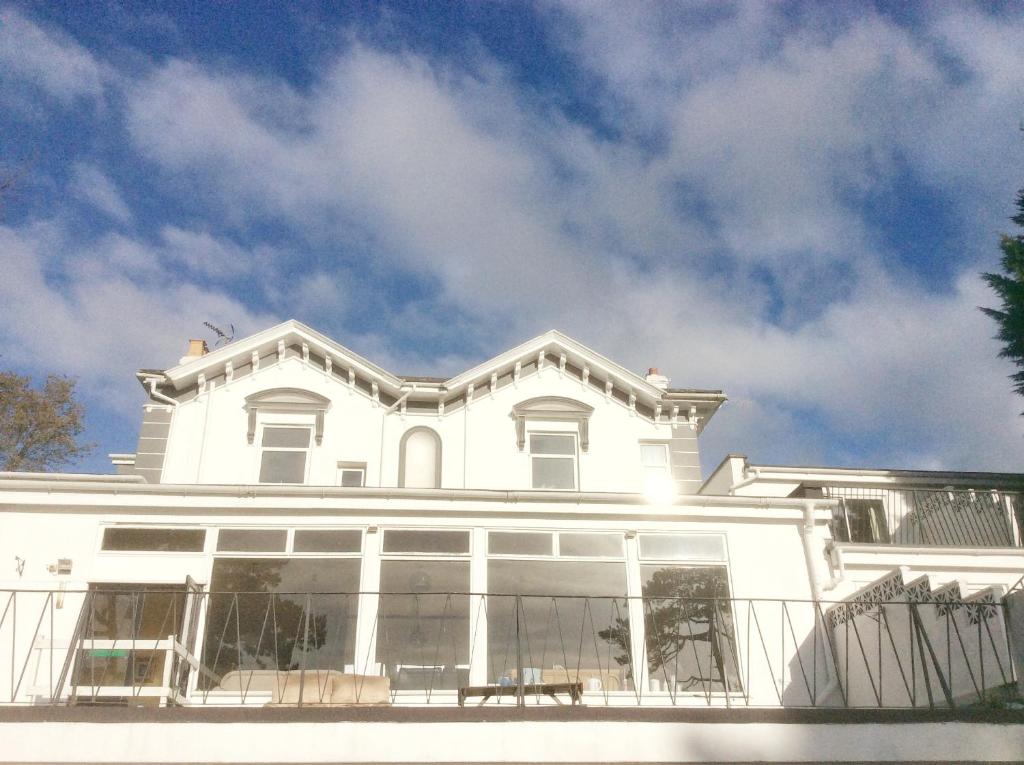 uma casa branca com o céu ao fundo em Inglewood Palm Hotel, Abbey Sands Torquay em Torquay