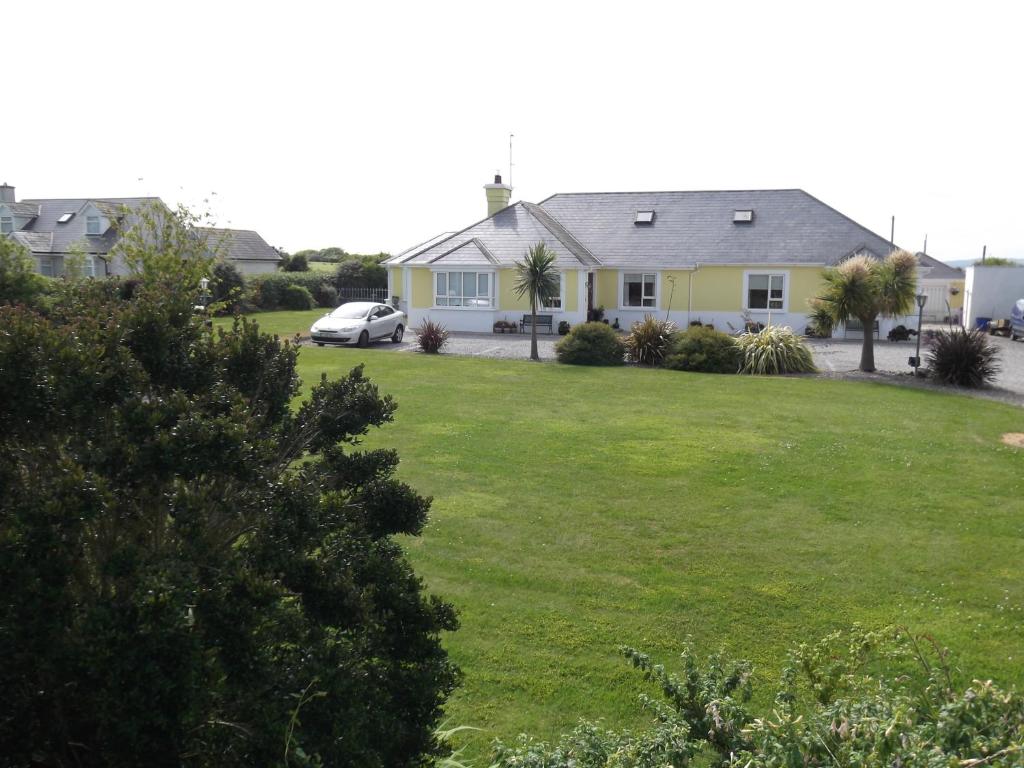 une maison avec une cour dotée d'une pelouse verdoyante dans l'établissement Ashley Lodge Bed & Breakfast, à Rosslare