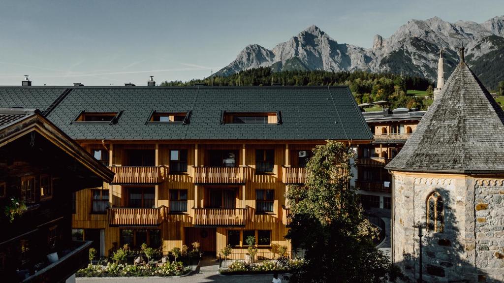 a large building with mountains in the background at PoSt Boutique Apartments in Maria Alm am Steinernen Meer