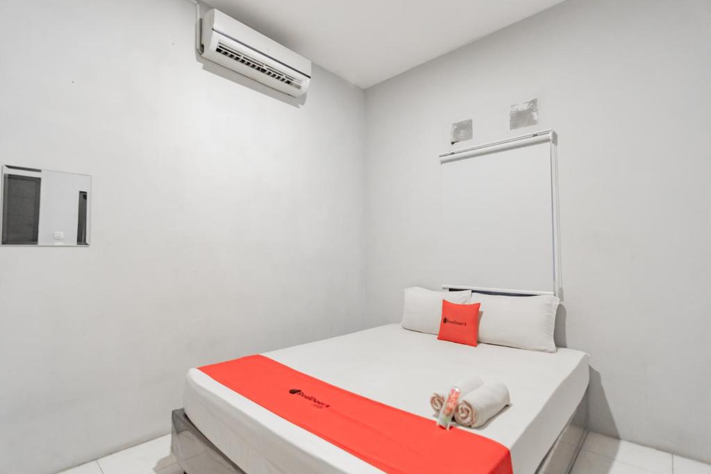 a white room with a bed with a red blanket at RedDoorz near Exit Toll Pasteur 4 in Bandung