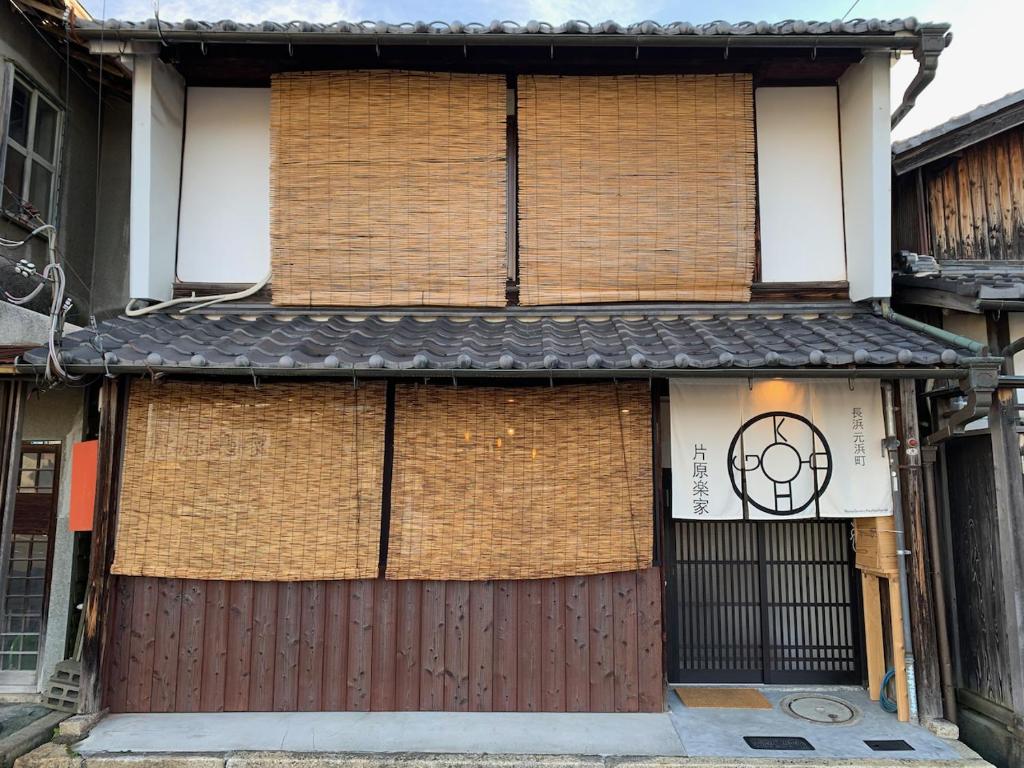 un bâtiment en briques avec un portail et un bâtiment avec un panneau sur celui-ci dans l'établissement 長濱元浜町宿場　片原楽家, à Nagahama