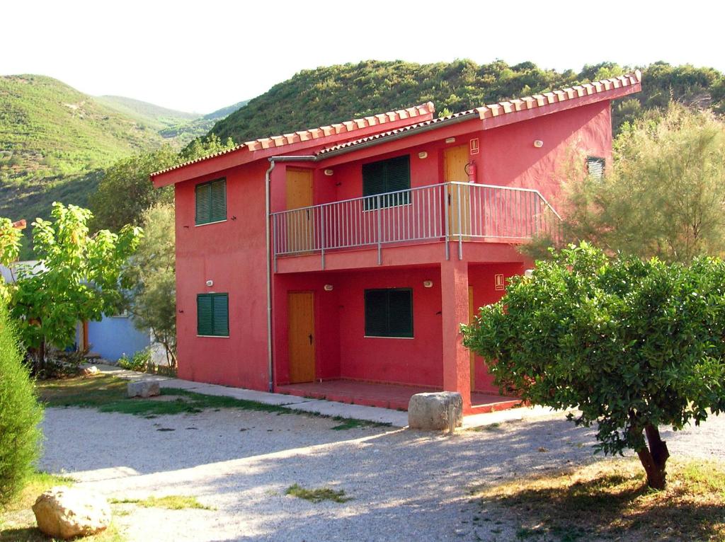 a red house with a balcony on the side of it at El Cerrao-PauNatura in Sot de Chera