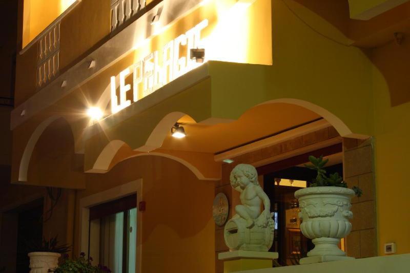 un bâtiment avec une statue devant lui dans l'établissement Hotel Le Pelagie, à Lampedusa