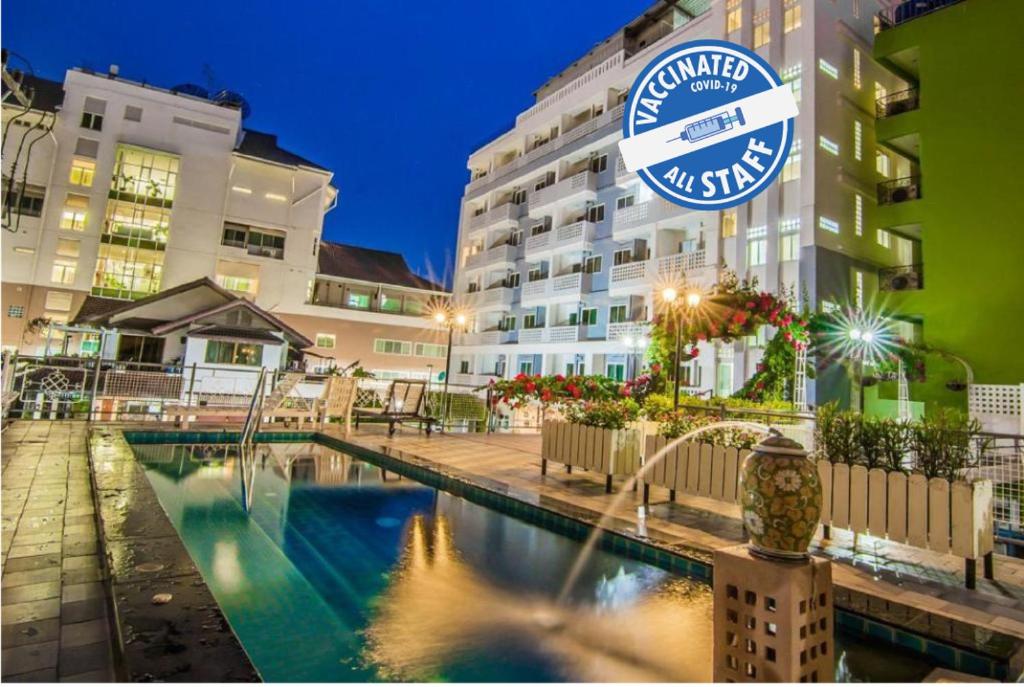a hotel with a swimming pool in front of a building at Sutus Court 1 in Pattaya