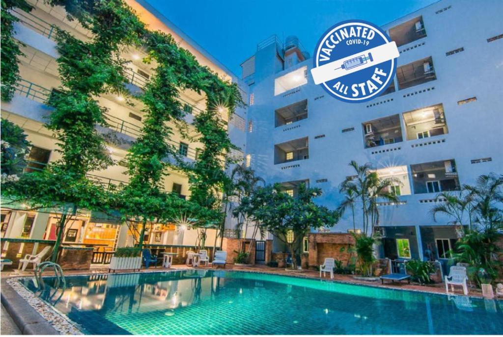 a hotel with a swimming pool in front of a building at Sutus Court 3 in Pattaya