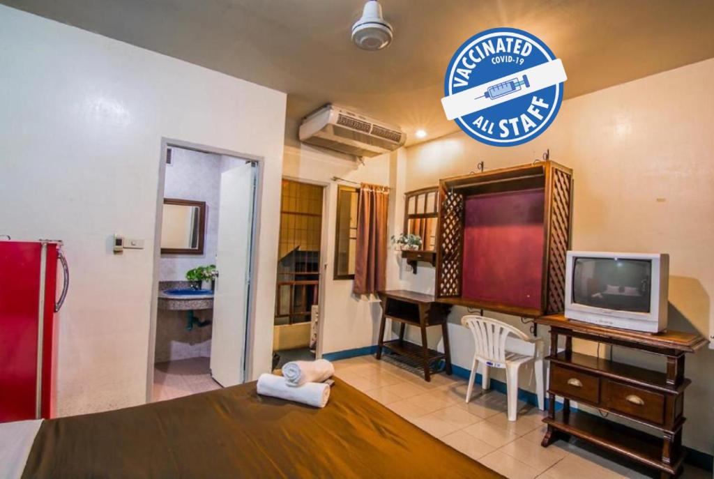 sala de estar con TV y escritorio con ordenador en Sutus Court 5, en Pattaya central