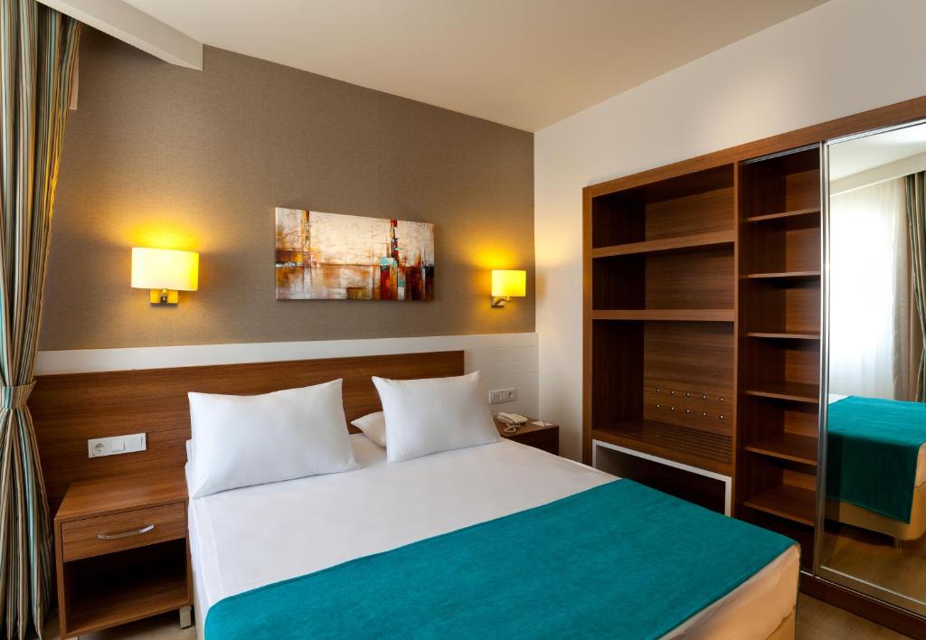 a hotel room with a bed and a closet at Grand Park Lara Hotel in Lara
