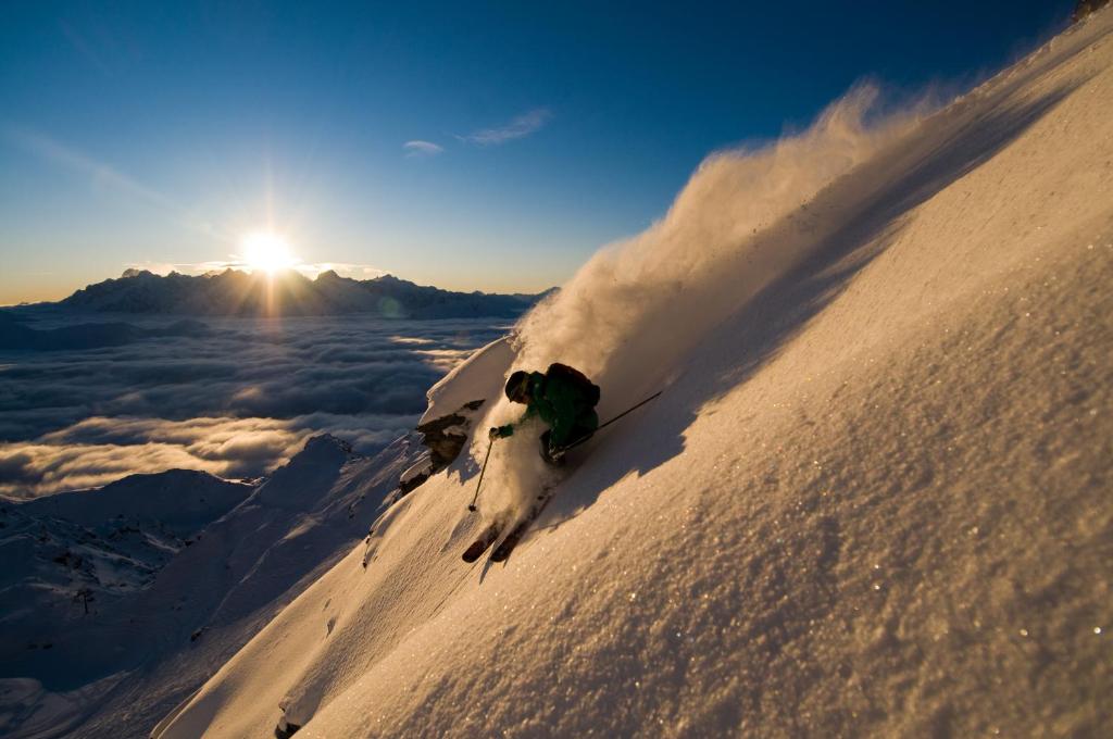 a person is skiing down a snow covered mountain at Hotel Montpelier in Verbier