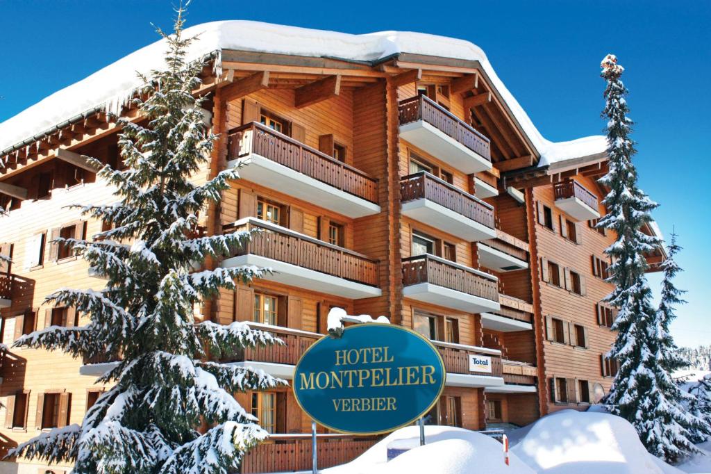 un grand bâtiment avec un panneau devant lui dans l'établissement Hotel Montpelier, à Verbier