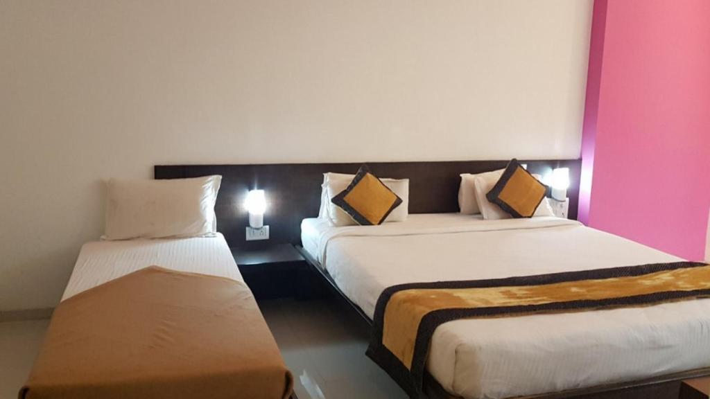 Postel nebo postele na pokoji v ubytování HOTEL SAI NISARG