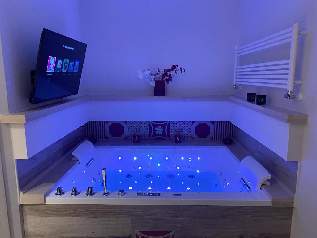 a jacuzzi tub with blue lighting in a room at MAD SUITES & APARTMENTS in Bernalda