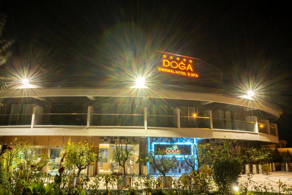 a building with a dosa sign at night at Doğa Thermal Health & Spa in Pamukkale