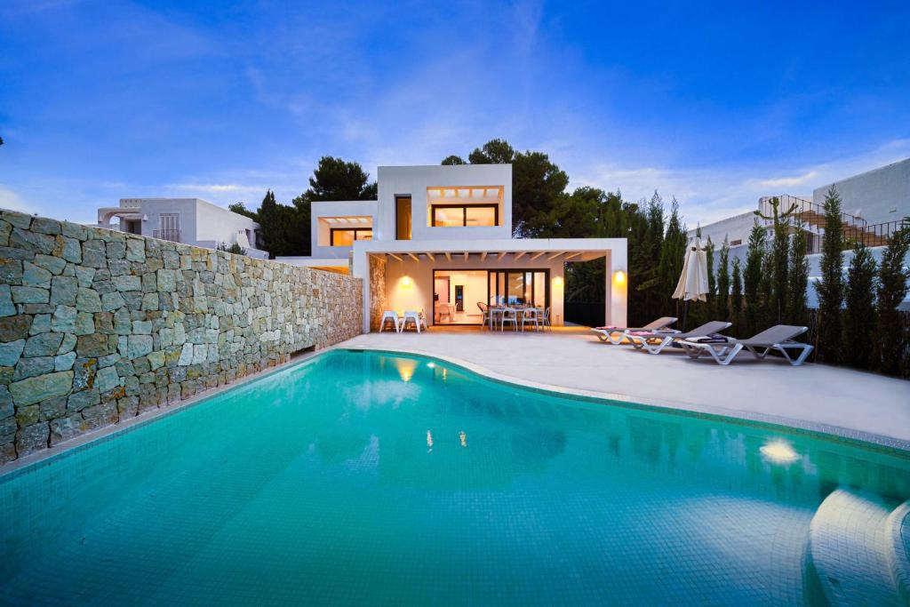 a villa with a swimming pool in front of a house at LA CALMA - Managed by Almarina in Moraira