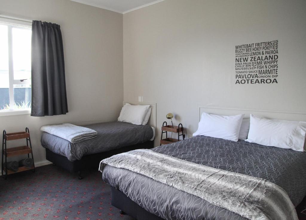 Un pat sau paturi într-o cameră la Hokitika Pioneer Hotel