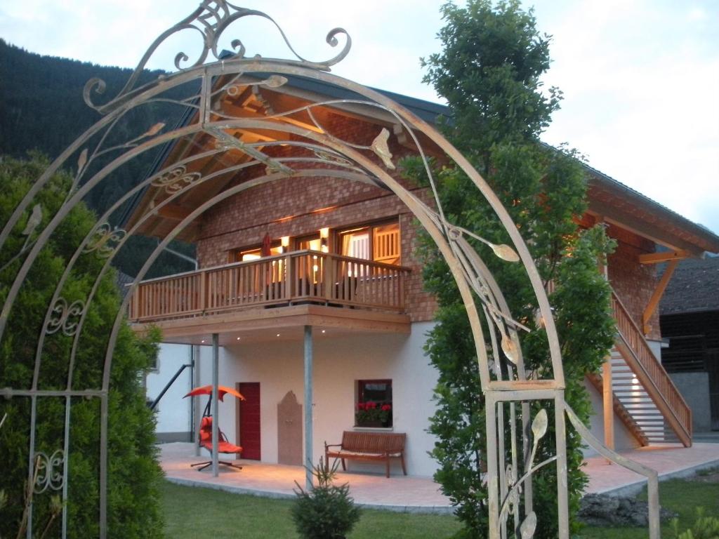 une maison avec un balcon et une tonnelle dans l'établissement Chalet Edelweiss im Montafon, à Sankt Gallenkirch
