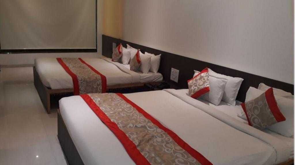Postel nebo postele na pokoji v ubytování HOTEL SAI NISARG