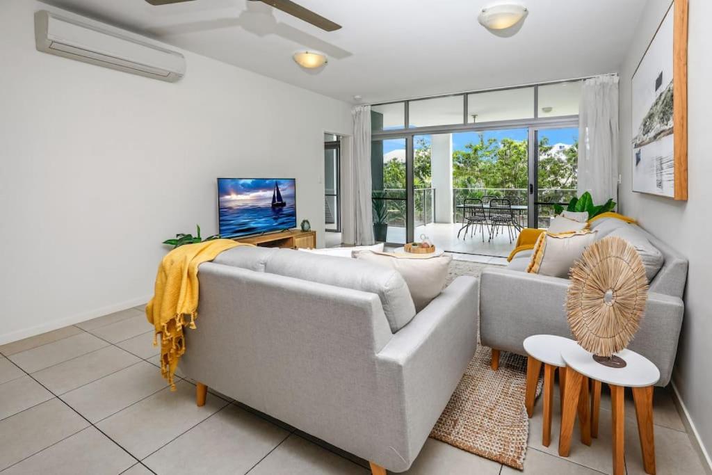 a living room with two couches and a tv at Pool View City Centre Apartment 206 in Cairns
