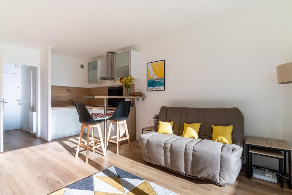 un salon avec un canapé et une cuisine dans l'établissement Maia, à La Baule