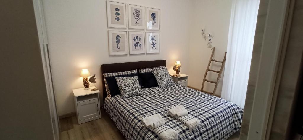 a bedroom with a bed and two tables with lamps at Casa Fronte del porto in Bari