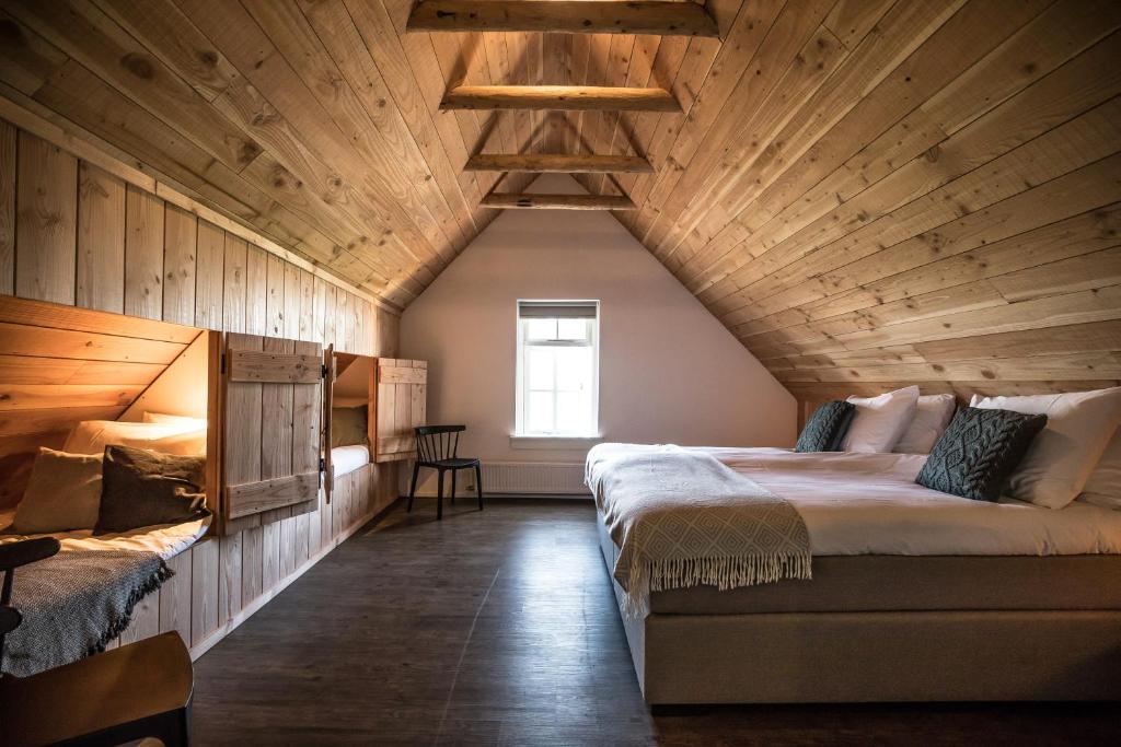 una camera con 2 letti e un soffitto in legno di Herberg de Pas a Haarle