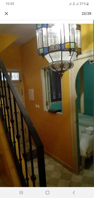 a room with a staircase with a chandelier and a stair case at Dar 21 in Tangier