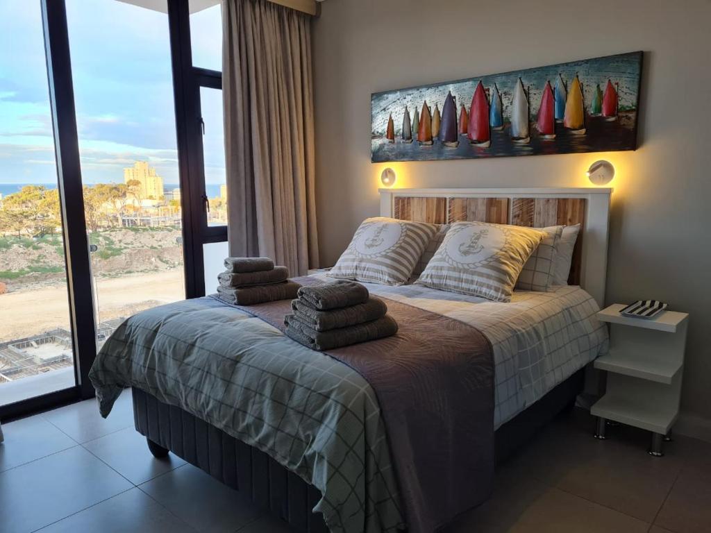 een slaapkamer met een bed en een groot raam bij BellaMare in Port Elizabeth