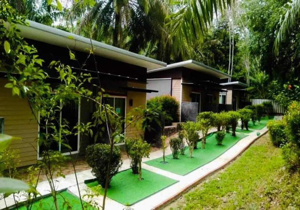 a house with a lot of trees in front of it at BaanPhong Lanta in Ko Lanta