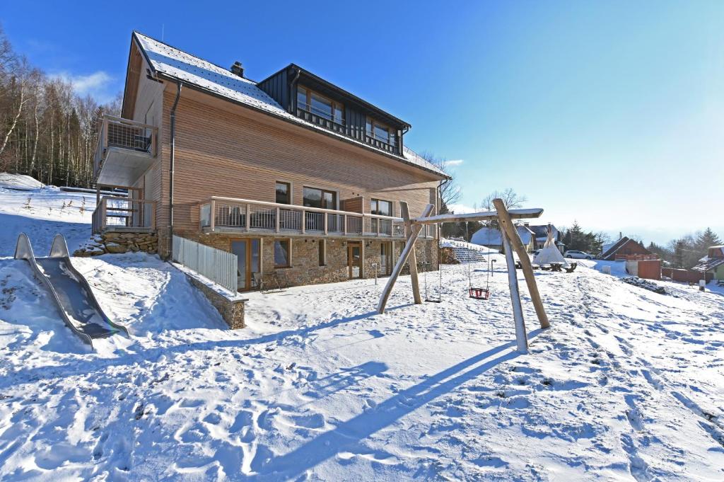 a house on a snow covered hill with a house at Vetrnik Depandance Hotelu Jirinka in Dolní Morava