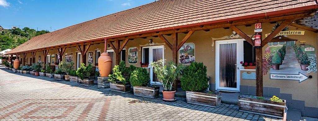 a building with potted plants on the side of it at Vadvirág Vendéglő és Panzió in Tatabánya