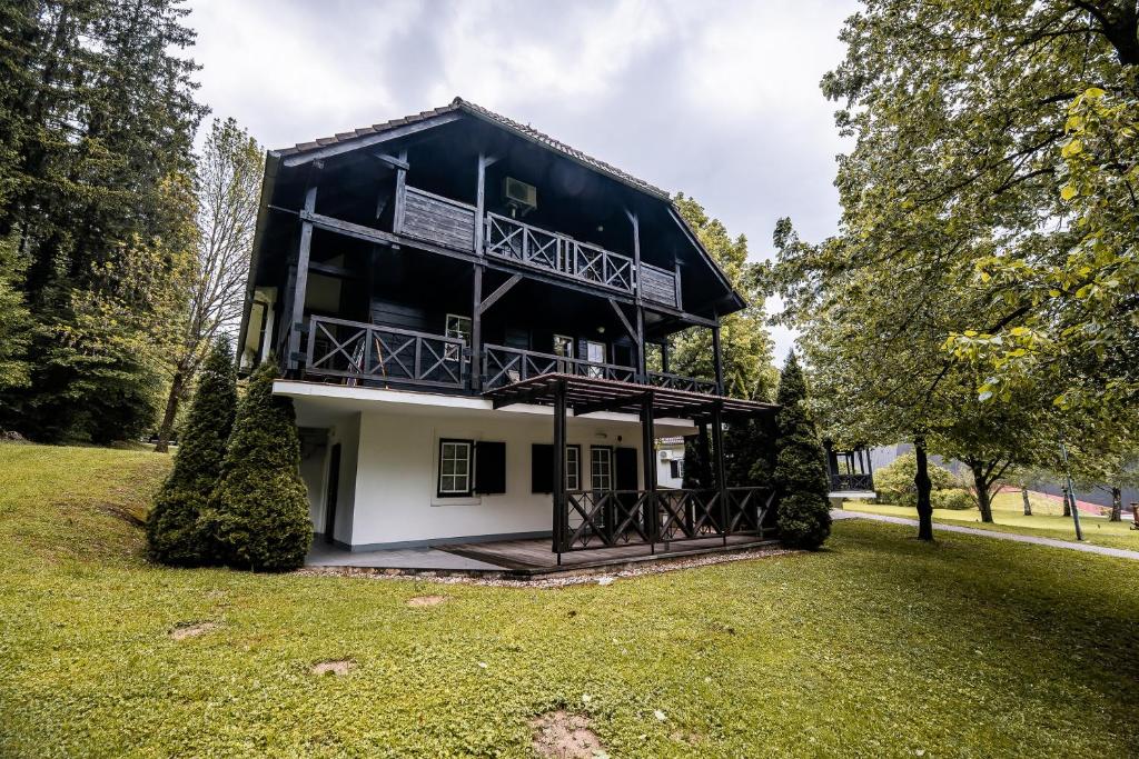 a house with a balcony in a park at Apartment Amy in Podčetrtek