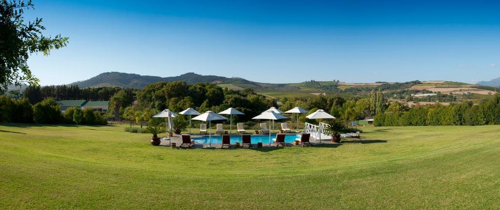 a resort with a pool and umbrellas in a field at Cultivar Boutique Hotel in Stellenbosch