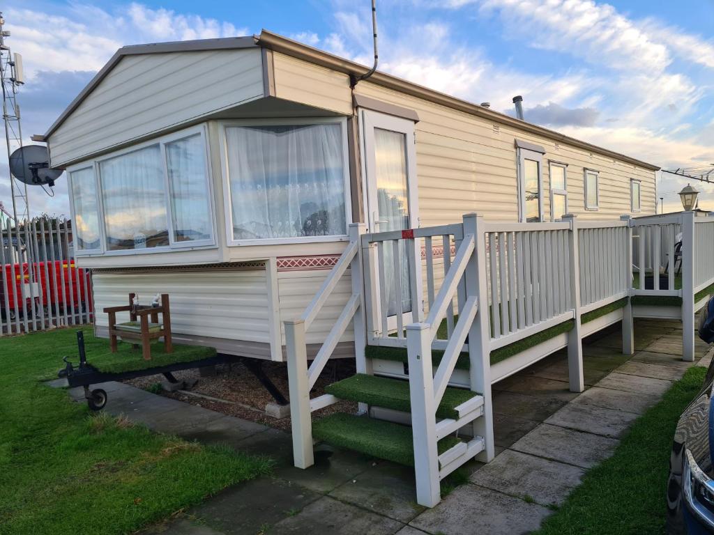 a tiny house with a porch and a staircase at 6 Berth Kingfisher (Firs) in Ingoldmells