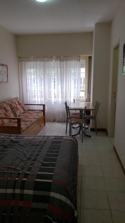 1 dormitorio con cama, mesa y comedor en Falucho en Mar del Plata
