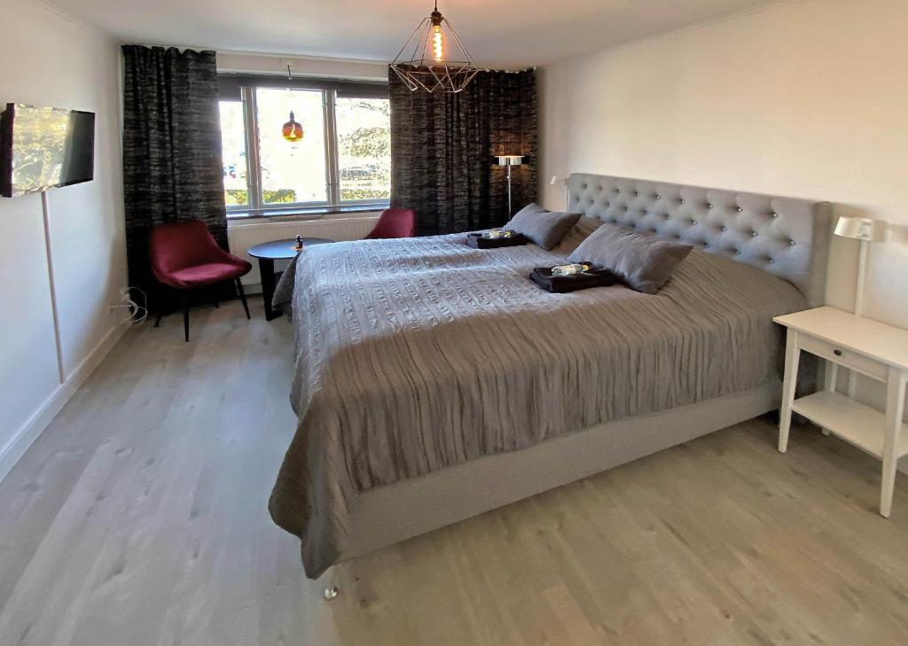 a bedroom with a large bed and a table and chairs at Vara Pensionat in Vara