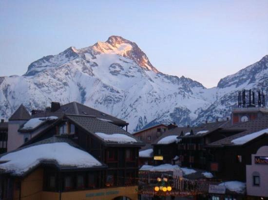 a snow covered mountain in front of a town with buildings at Boost Your Immo Les Ecrins 6 Les 2 Alpes 659 in Les Deux Alpes