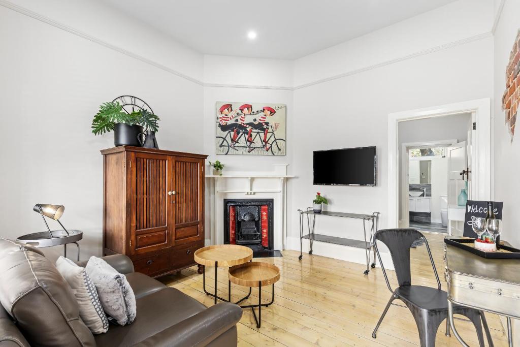 a living room with a couch and a fireplace at Boutique Heritage listed Studios On Ryrie st Geelong CBD in Geelong