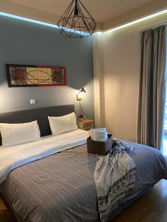 a bed with a white comforter and pillows on it at Central Rooms in Kalamata