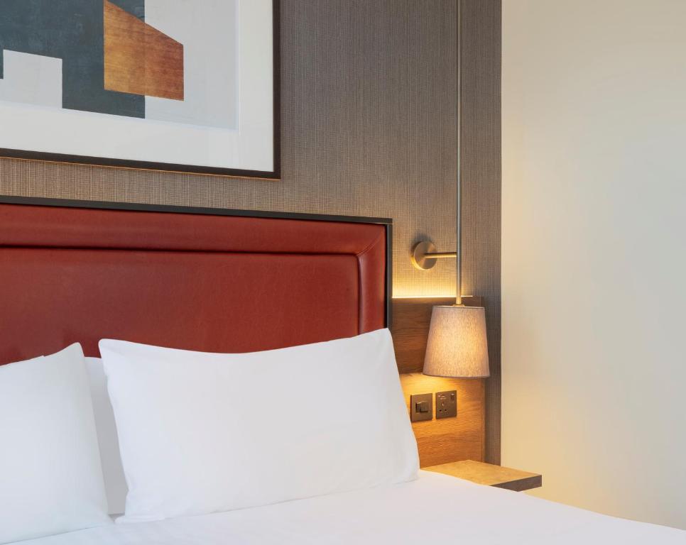 a hotel room with a bed and a lamp at Jurys Inn Birmingham in Birmingham