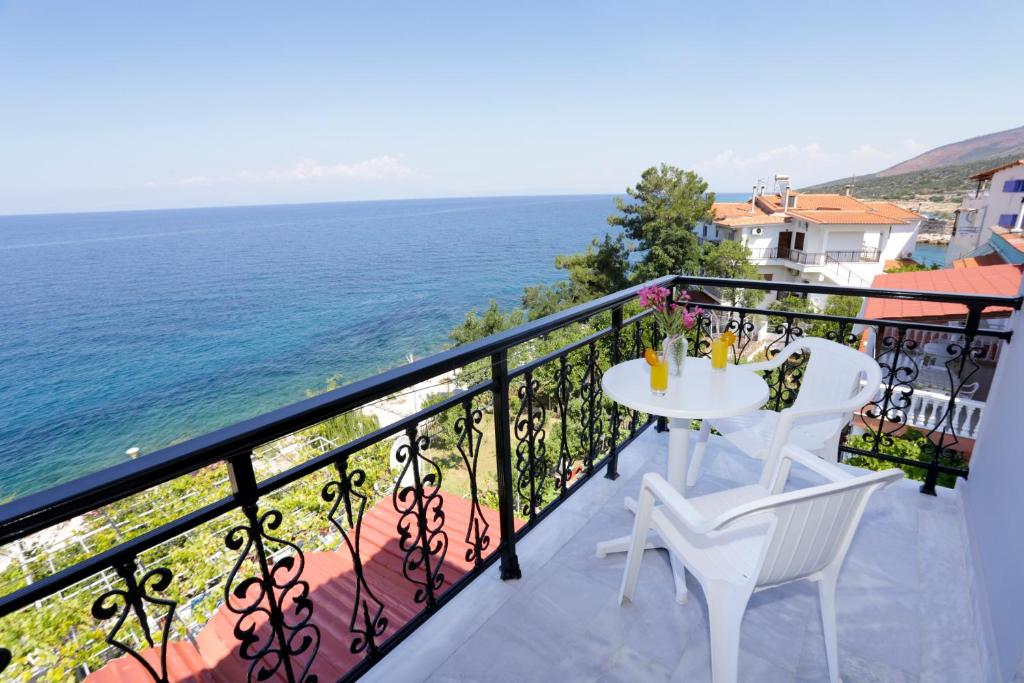 a balcony with a table and chairs and the ocean at Sunset Studios in Skala Marion