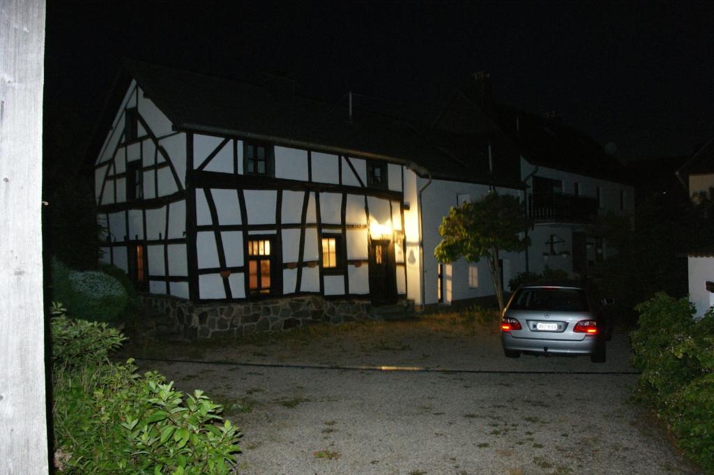 Hecken的住宿－Authentiek Eifelhuis，夜间停在房子前面的汽车