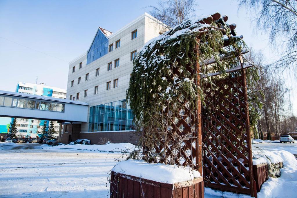 Un árbol de Navidad en una valla en la nieve en 40th Meridian Yacht Club en Kolomna