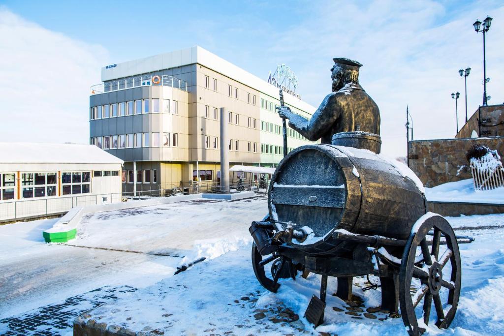 Una estatua de un hombre en un carro en la nieve en 40th Meridian Arbat Hotel, en Kolomna