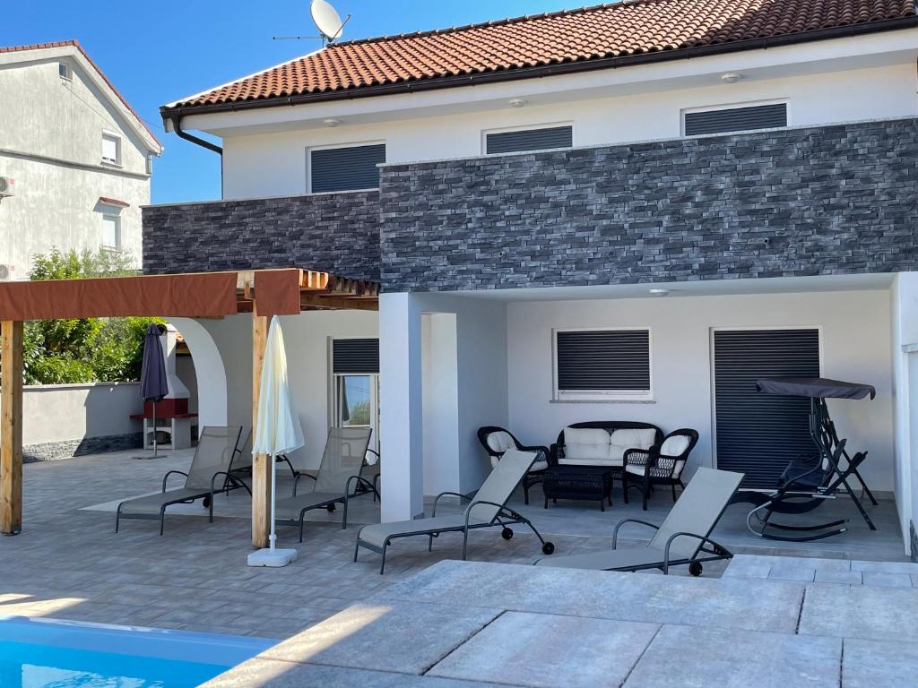 a patio with chairs and a table next to a house at Villa Mira ***** in Pinezici