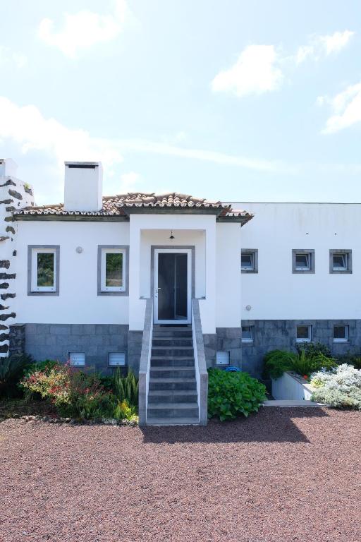 ein weißes Haus mit einer Treppe, die zu einer Tür führt in der Unterkunft Casa da Malta in Livramento