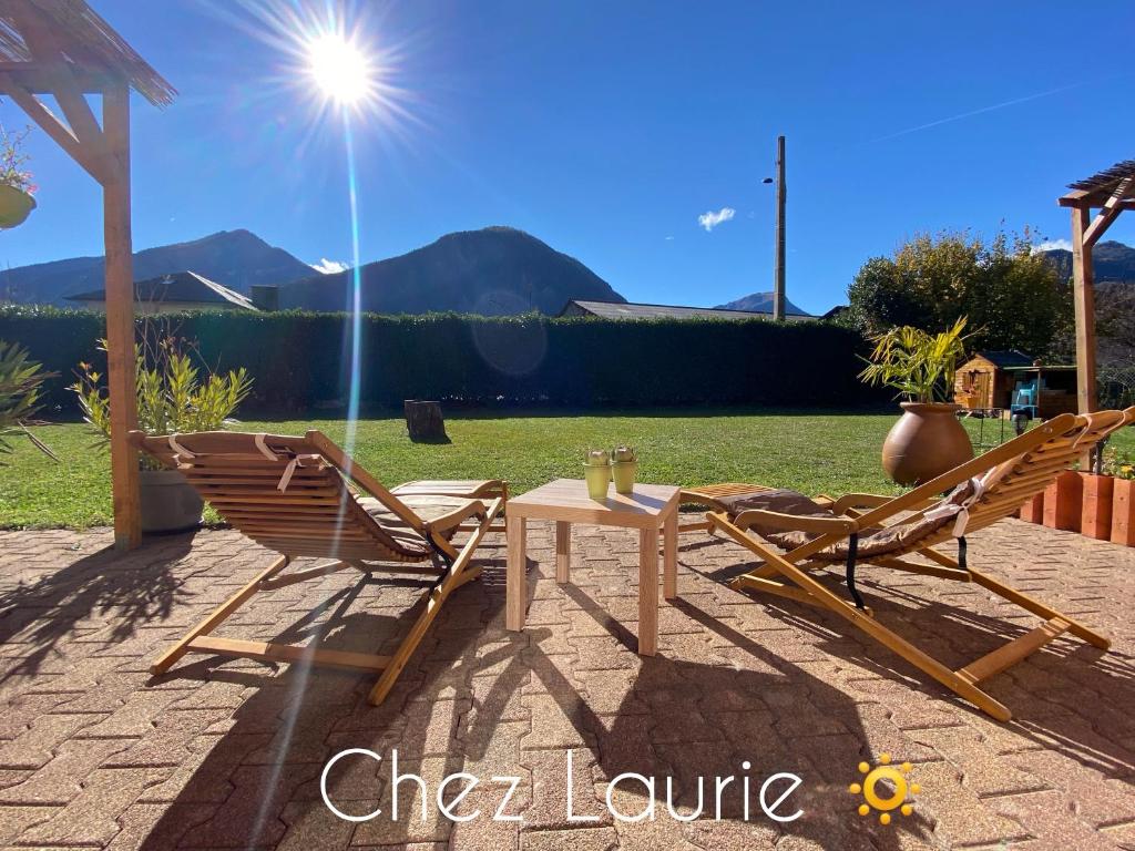 a pair of chairs and a table in a yard at Appartement douillet, proche gare, terrasse, cave in Saint-Jean-de-Maurienne