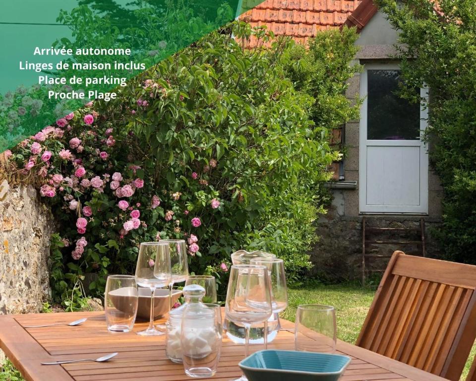 uma mesa de madeira com copos de vinho em cima em Holiday Normandy se ressourcer à deux pas de la Mer em Fermanville