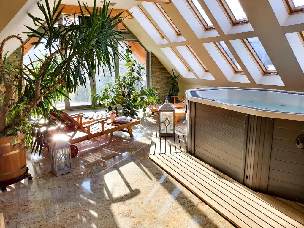 ein großes Bad mit Whirlpool in einem Zimmer mit Pflanzen in der Unterkunft Rysy Boutique Hotel in Zakopane