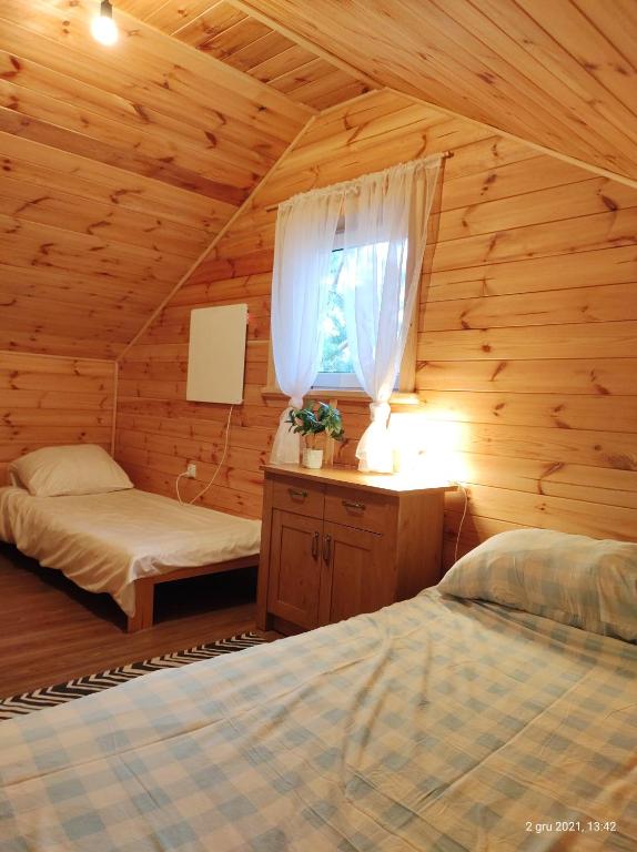 a bedroom with two beds in a wooden cabin at Wiejska Sielanka noclegi Ustroń in Ustroń