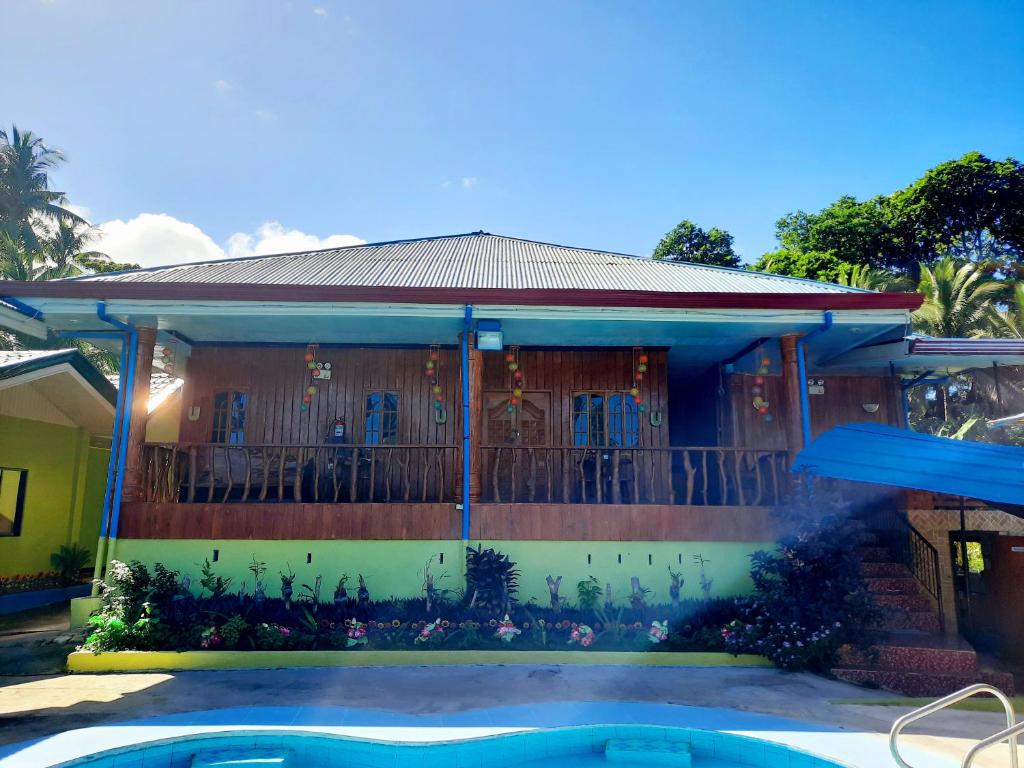 a house with a swimming pool in front of it at Villa Corrales Homestay in Mambajao