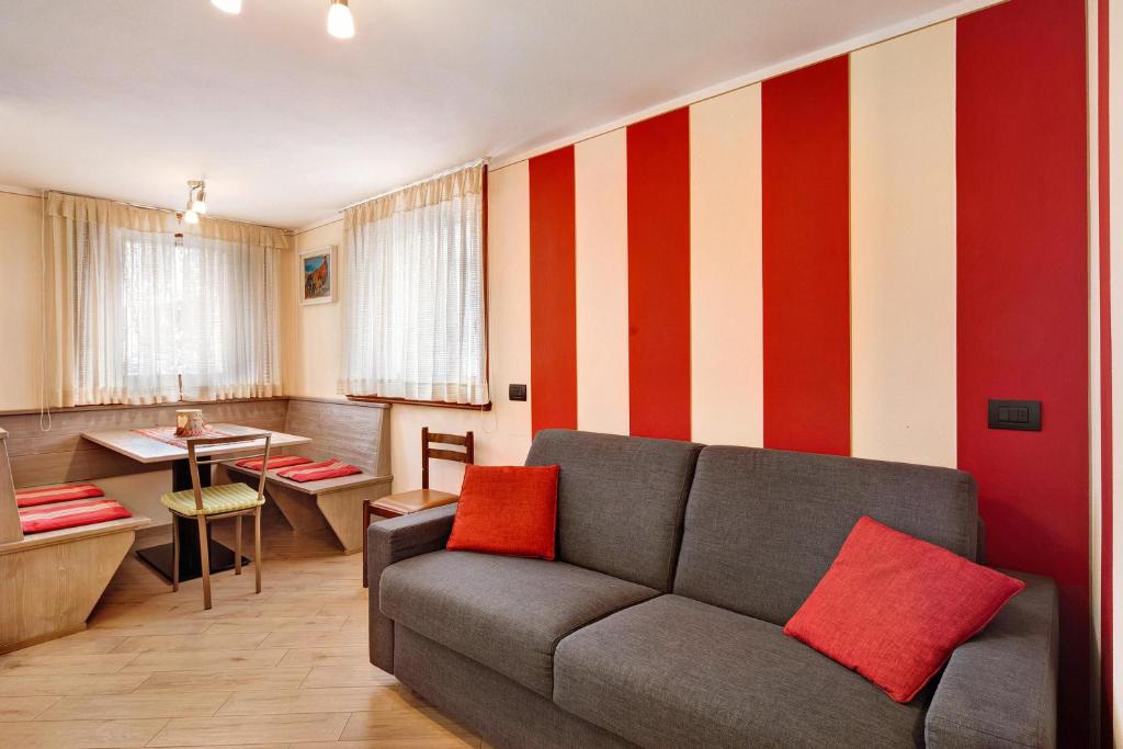 een woonkamer met een bank en een rode en witte streepmuur bij Baita Nicoletta Red in Livigno
